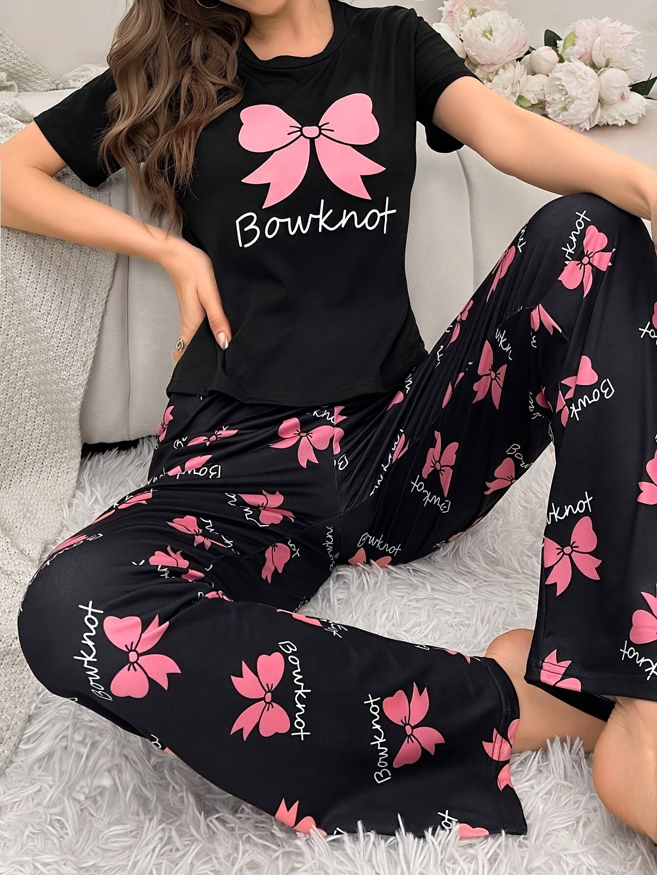 Cozy bowknot pajama set for women with short sleeves and elastic waistband pants. Made from soft, machine washable polyester blend in black with pink butterfly print.