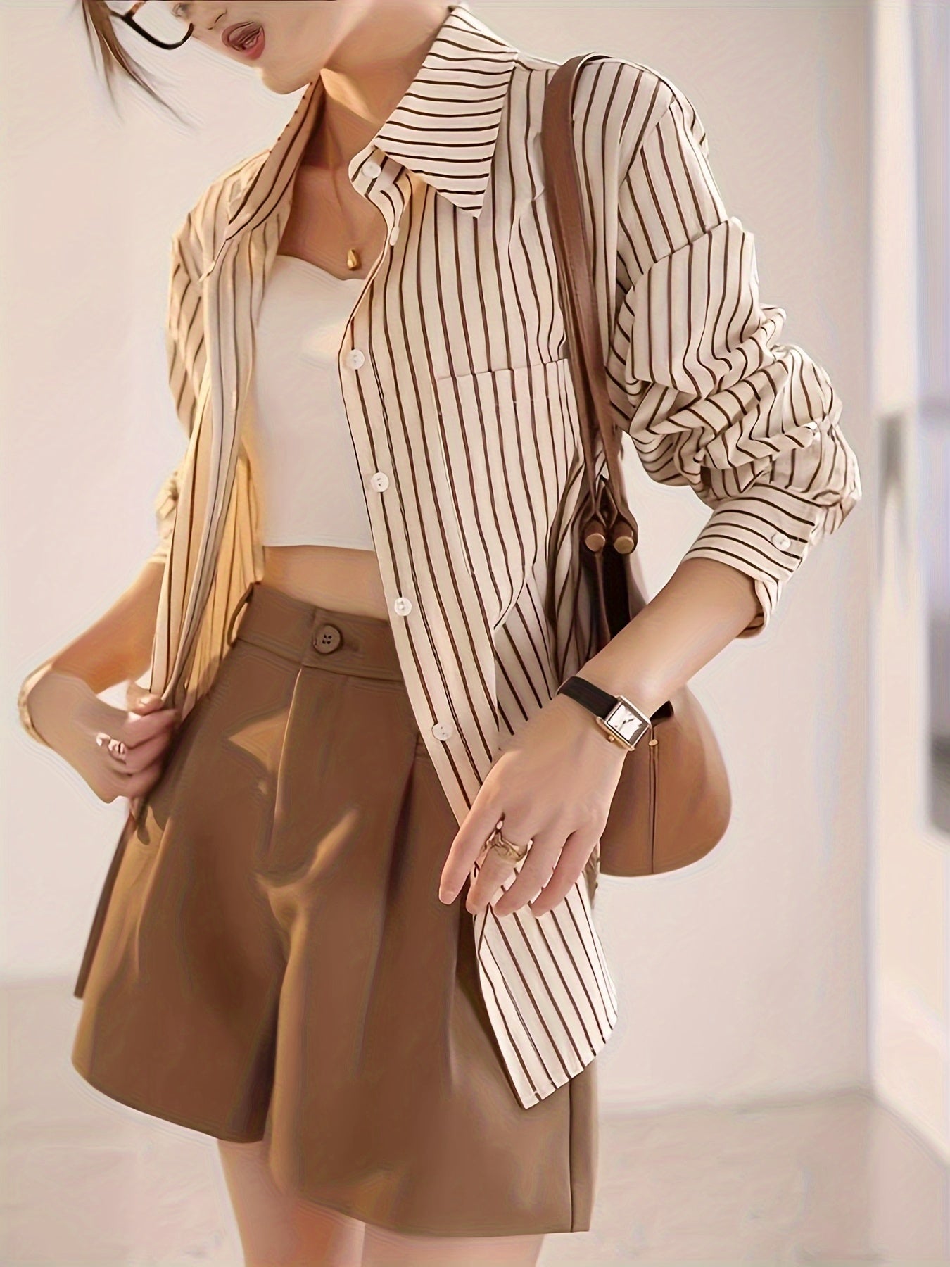 Elegant striped button-up shirt for women with a French-inspired design in beige and brown vertical stripes for spring/summer.