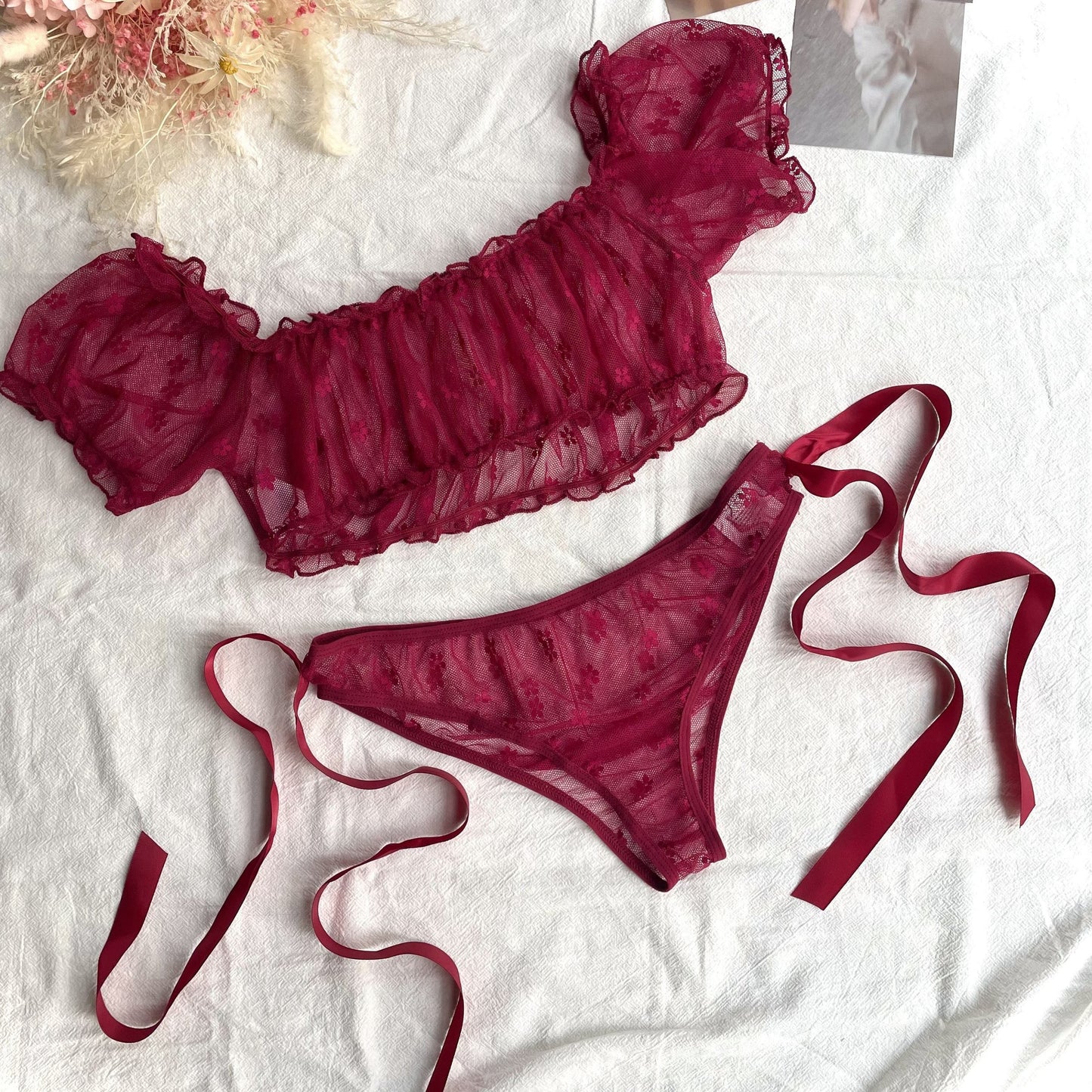 Red lace lingerie set with off-shoulder bra and low-rise panties for women.