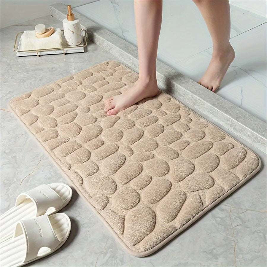 One piece of bath mat with embossed pebble pattern, highly absorbent and non-slip for bathroom use. Suitable for tub, toilet, and floor, made of machine washable polyester material. Dimensions are 59.94x39.88 cm.