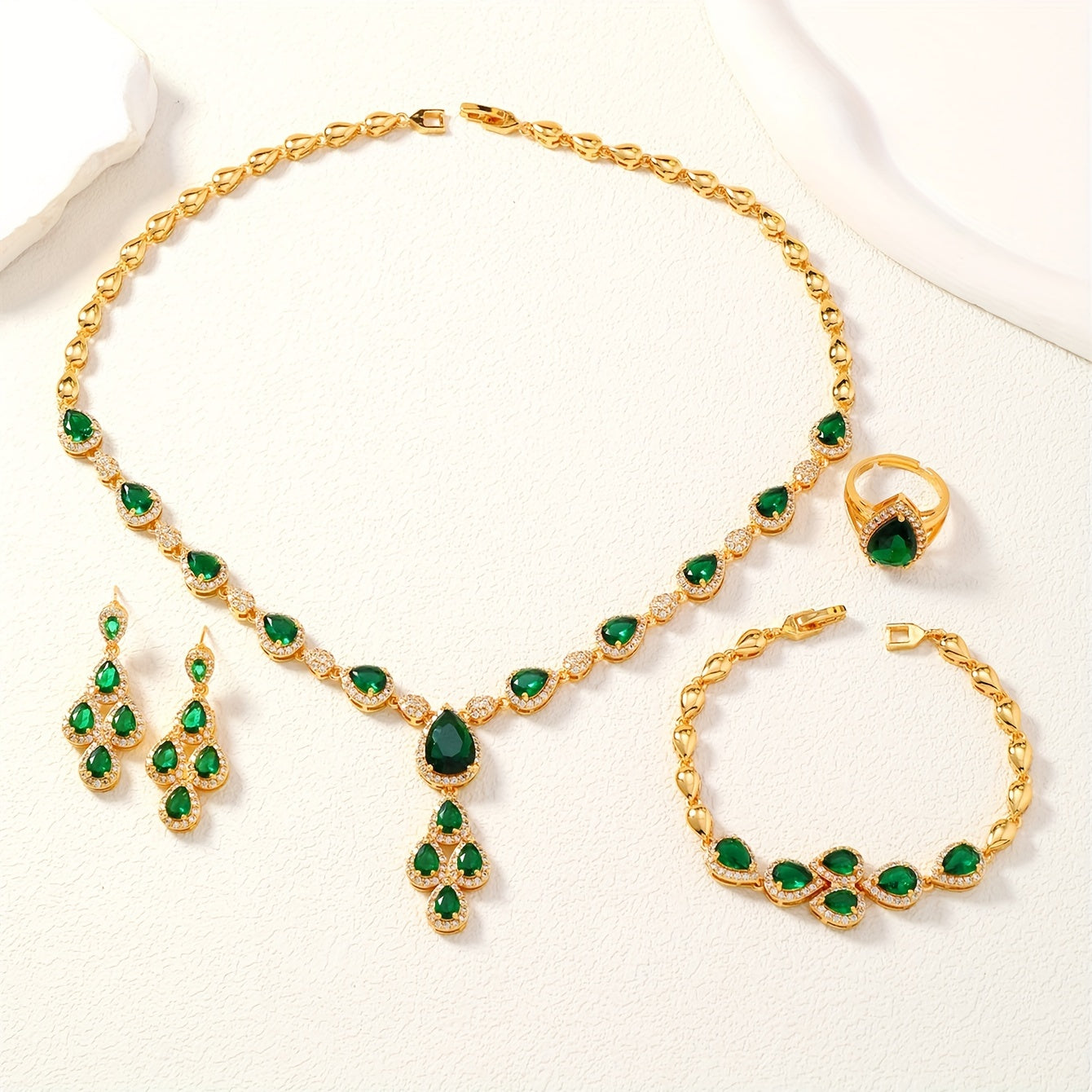 A set of four pieces of stunning Middle Eastern women's wedding jewelry from Saudi Arabia, featuring full inlay peacock green water drop-shaped cubic zirconia on copper. The set includes one necklace, one bracelet, one ring, and one pair of earrings.