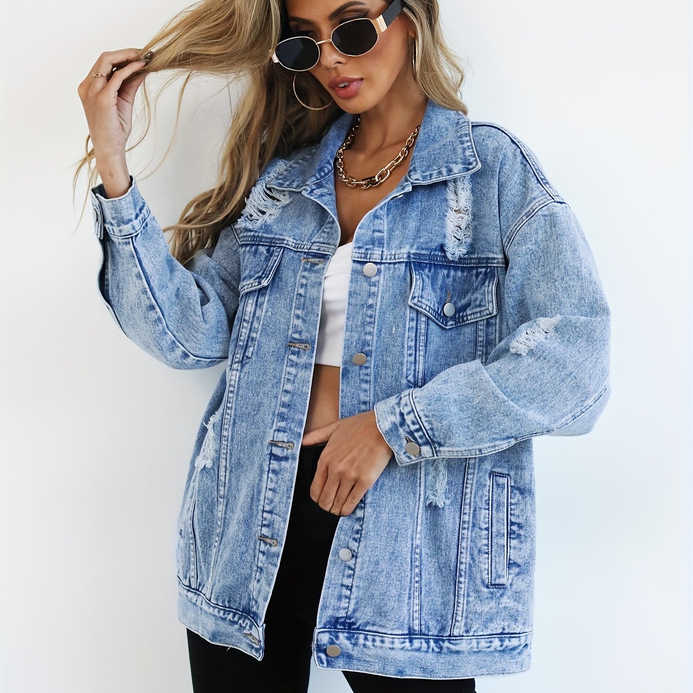 Casual light blue denim jacket for women with distressed, loose fit and ripped detailing, featuring long sleeves, flap pockets, and button closure. Made from a blend fabric and machine