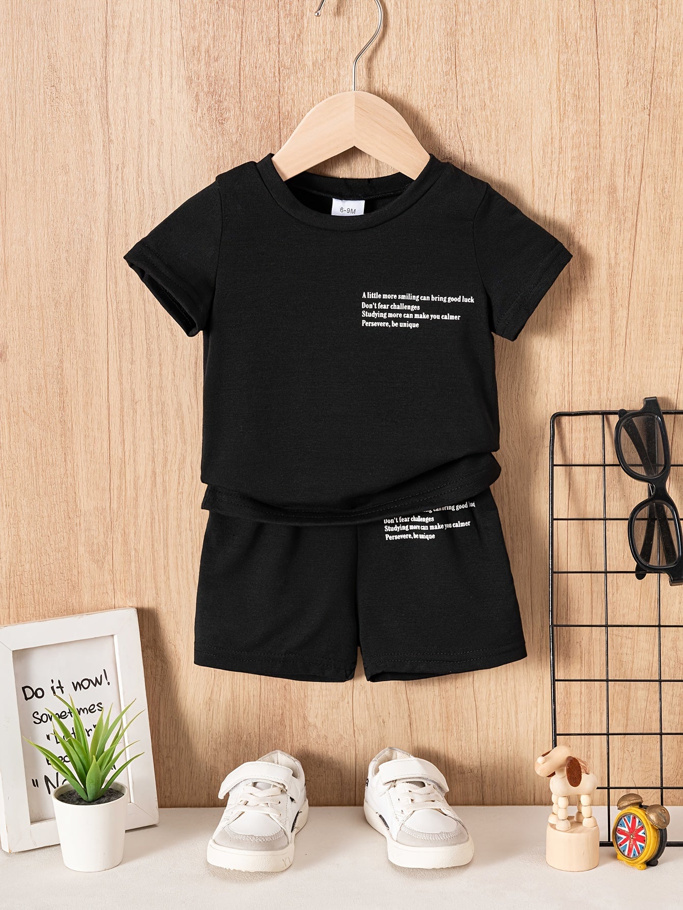 Two baby boy casual "slogan" t-shirt and shorts set made of polyester knit fabric, featuring a cute regular fit. The set includes a short sleeve crew neck tee with solid color shorts