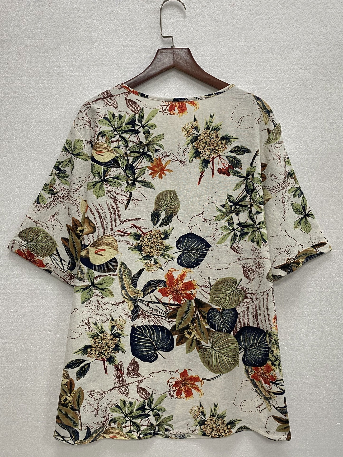 Plus size tropical print blouse for women, casual and loose fit, short sleeve, round neck, polyester blend, machine washable, vibrant floral design with asymmetrical hem.