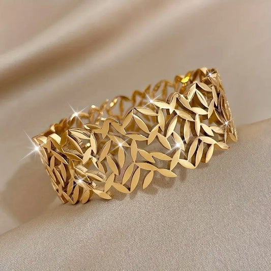 A stylish stainless steel bangle for women, featuring a delicate two-tone design with an irregular hollowed-out leaf bird's nest pattern. This fashionable botanical accessory is perfect for adding a touch of elegance to any outfit and makes a great gift