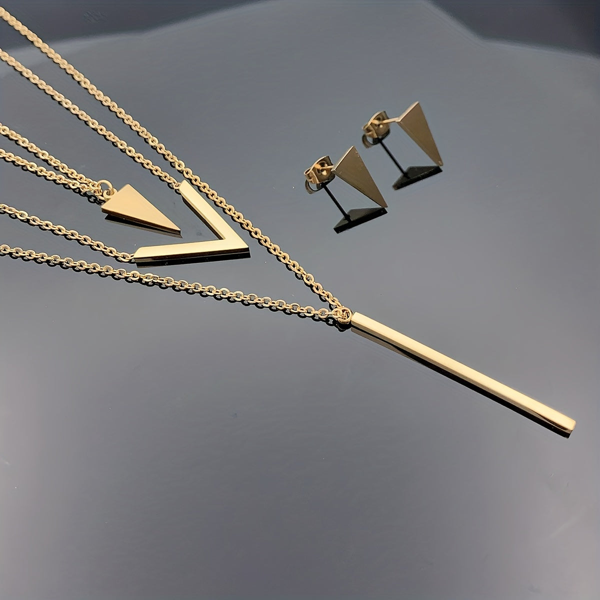 Three pieces of Stainless Steel Long Strip V-shaped Geometric Pendant with a Multi-layer Necklace and Triangle Earrings. Perfect as a Birthday or Holiday Gift, Clothing Decoration, or Party Accessories.