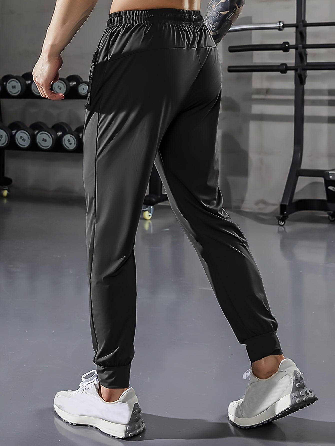 Men's athletic stretch pants with adjustable drawstring waist, zippered pockets, solid color, quick-dry material, ideal for fitness and running.