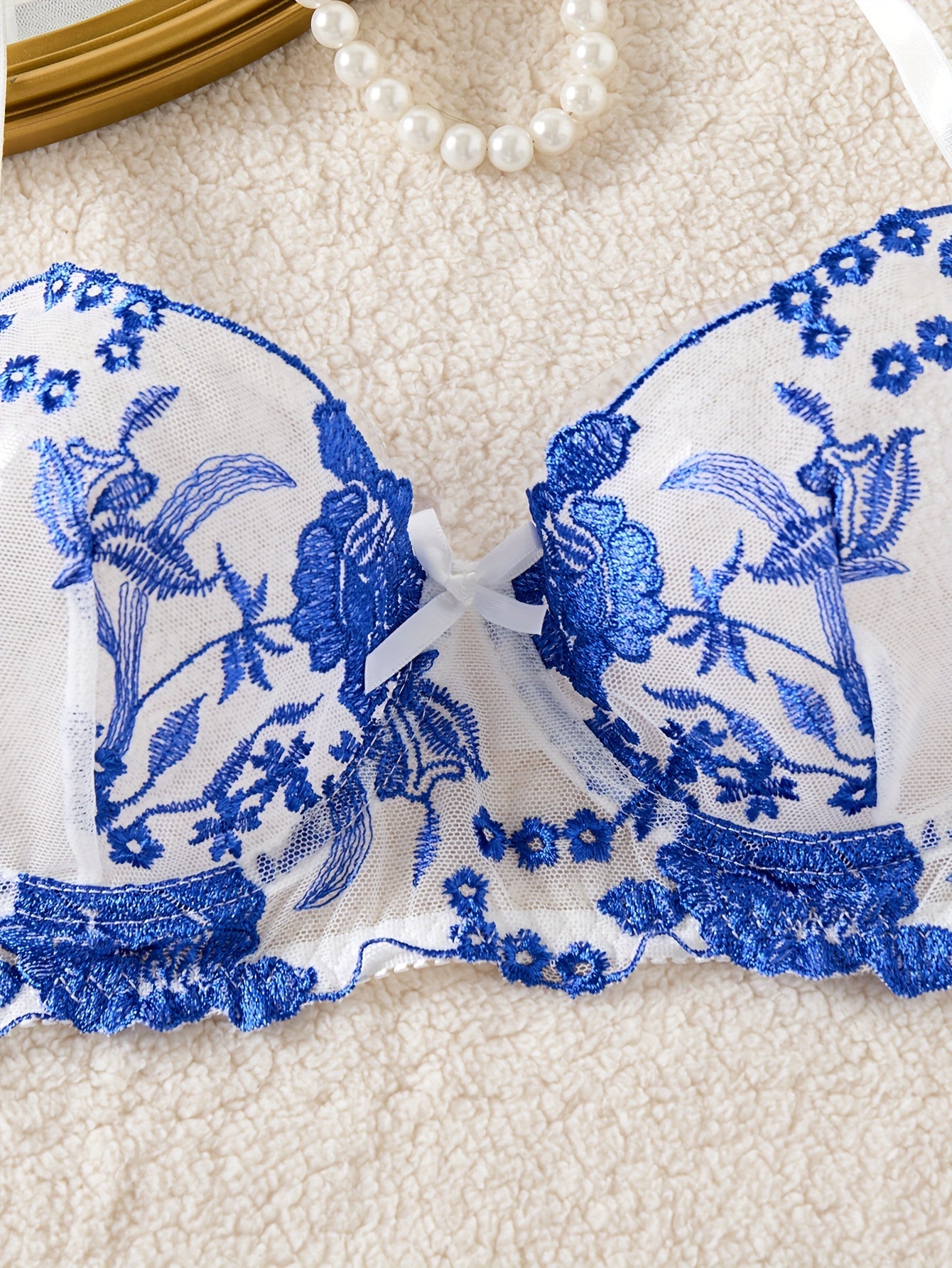 Blue floral embroidered lingerie set with medium support bra and matching thong. Perfect for parties, drop waist style in knit fabric.