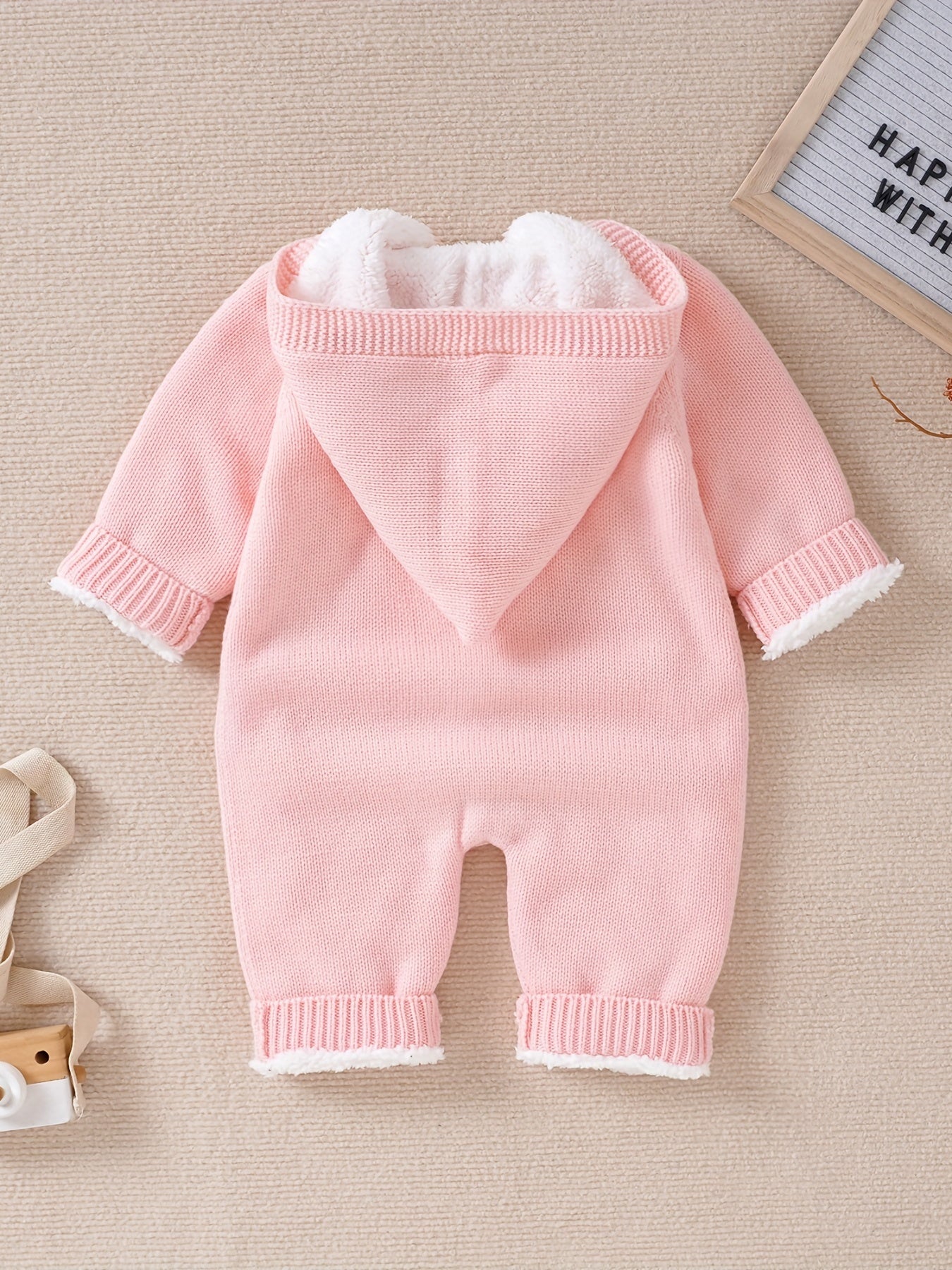 Knitted jumpsuit for newborn boys and girls with long sleeves and hooded pants.