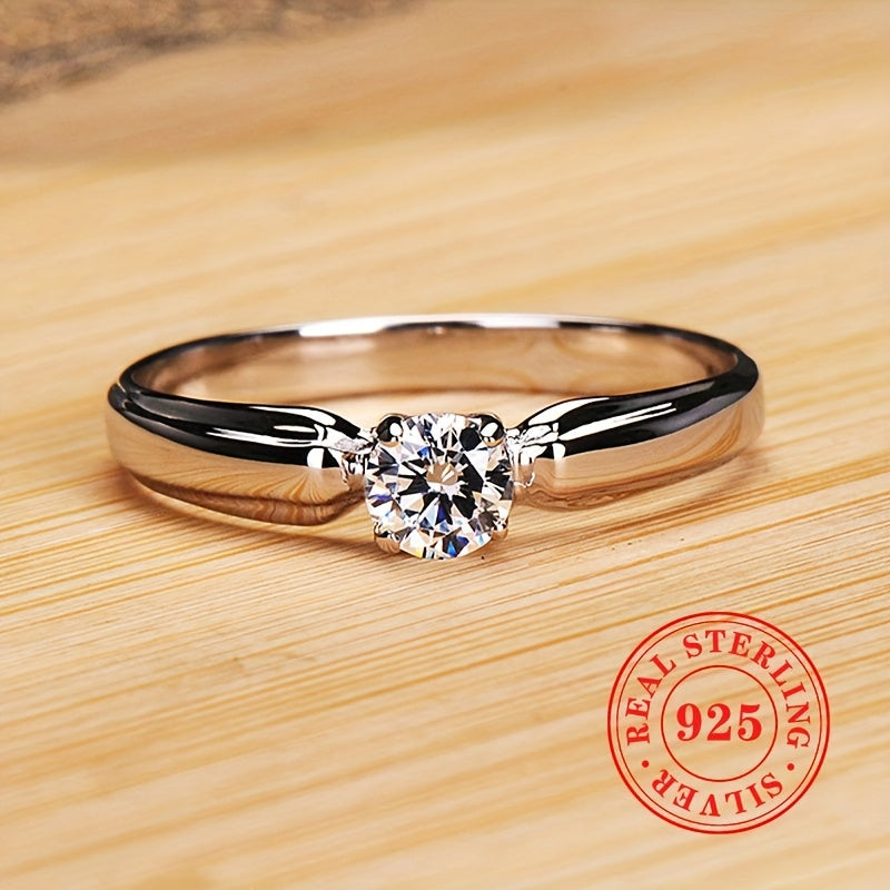 An elegant 925 sterling silver engagement ring featuring a dazzling zirconia stone held securely in four prongs. Perfect for brides, ideal for weddings, and a luxurious jewelry gift for any special occasion.