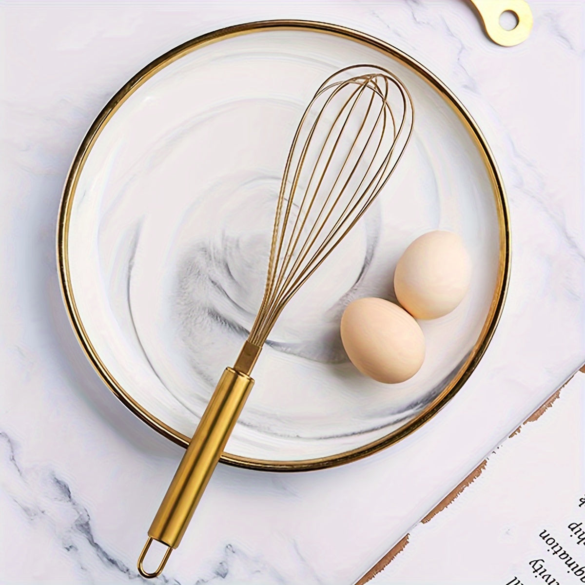 Golden Stainless Steel Egg Whisk is a versatile baking tool that is perfect for cooking in nonstick cookware. This heat-resistant kitchen whisk can be used for mixing, whirling, foaming, and stirring food.