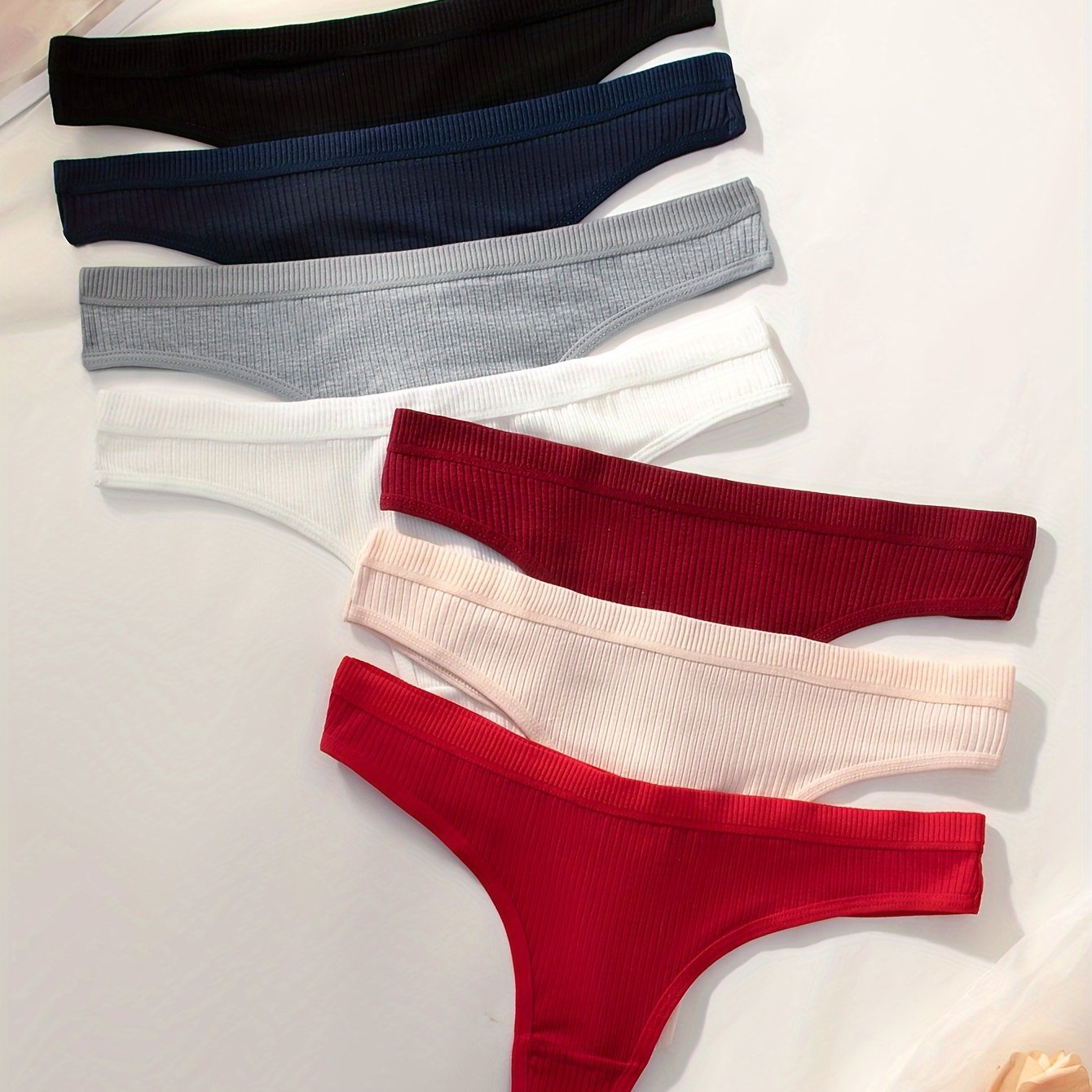 7-pack of women's ribbed thongs in solid colors, made of soft, stretchy polyester blend. Non-see-through, great for casual wear.