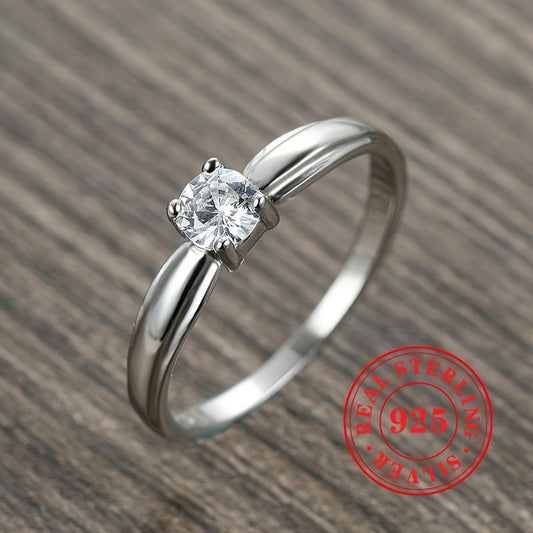 An elegant 925 sterling silver engagement ring featuring a dazzling zirconia stone held securely in four prongs. Perfect for brides, ideal for weddings, and a luxurious jewelry gift for any special occasion.