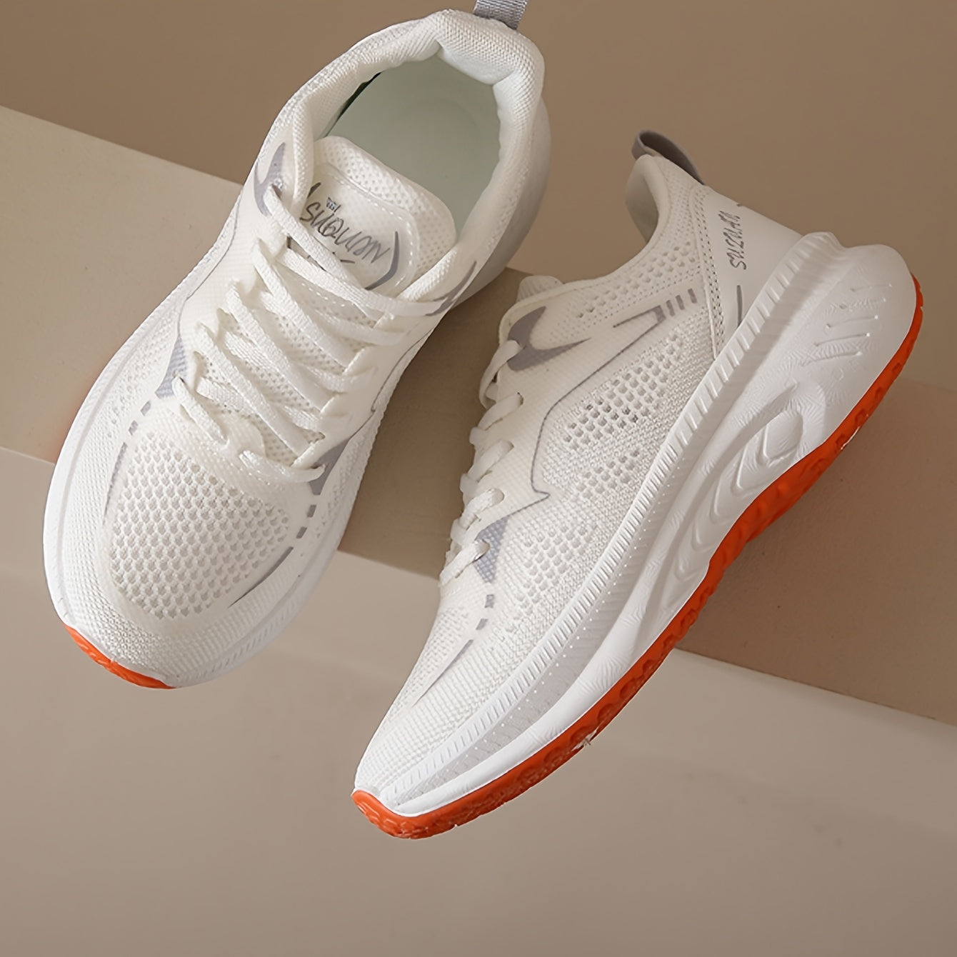 Women's low-top running shoes in white with orange sole, breathable fabric upper, rubber sole, stabilizing support, all-season casual sneakers.