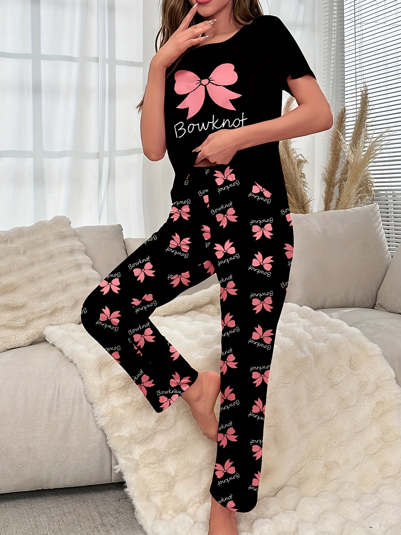 Women's sleepwear set with bow & slogan print, short sleeve top, and elastic pants.