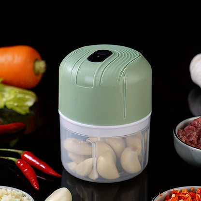 Round plastic container containing a portable multifunctional food chopper that is USB rechargeable. This versatile appliance can be used as a vegetable dicer, garlic masher, manual food processor, and electric mini kitchen appliance with a lithium