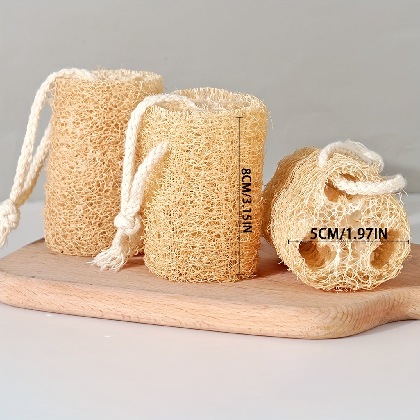 A set of four natural loofah sponges made from wood pulp fiber. These rectangular sponges are lightweight and made from non-woven fabric, making them reusable for various purposes such as bathing, spa treatments, skincare, kitchen cleaning, dishwashing