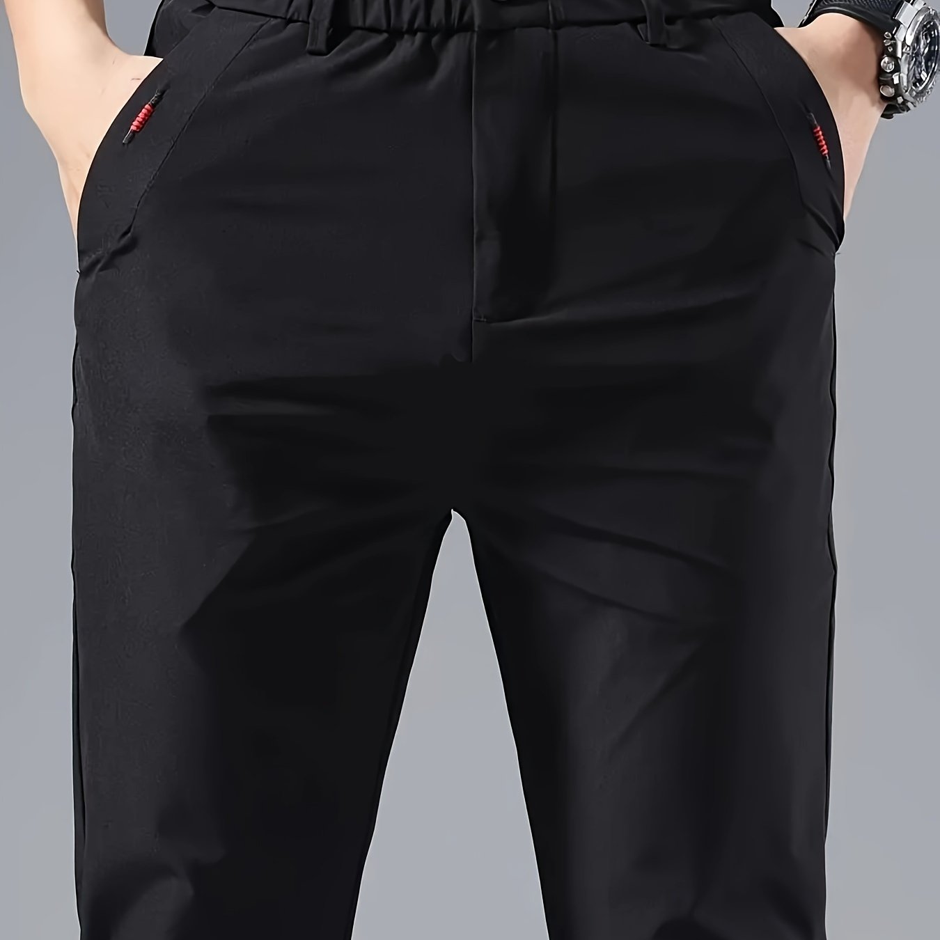 Men's slim fit casual pants made of breathable nylon fabric with pockets and embroidery. Suitable for outdoor and daily wear in a solid color basic style. Features zippered waist for