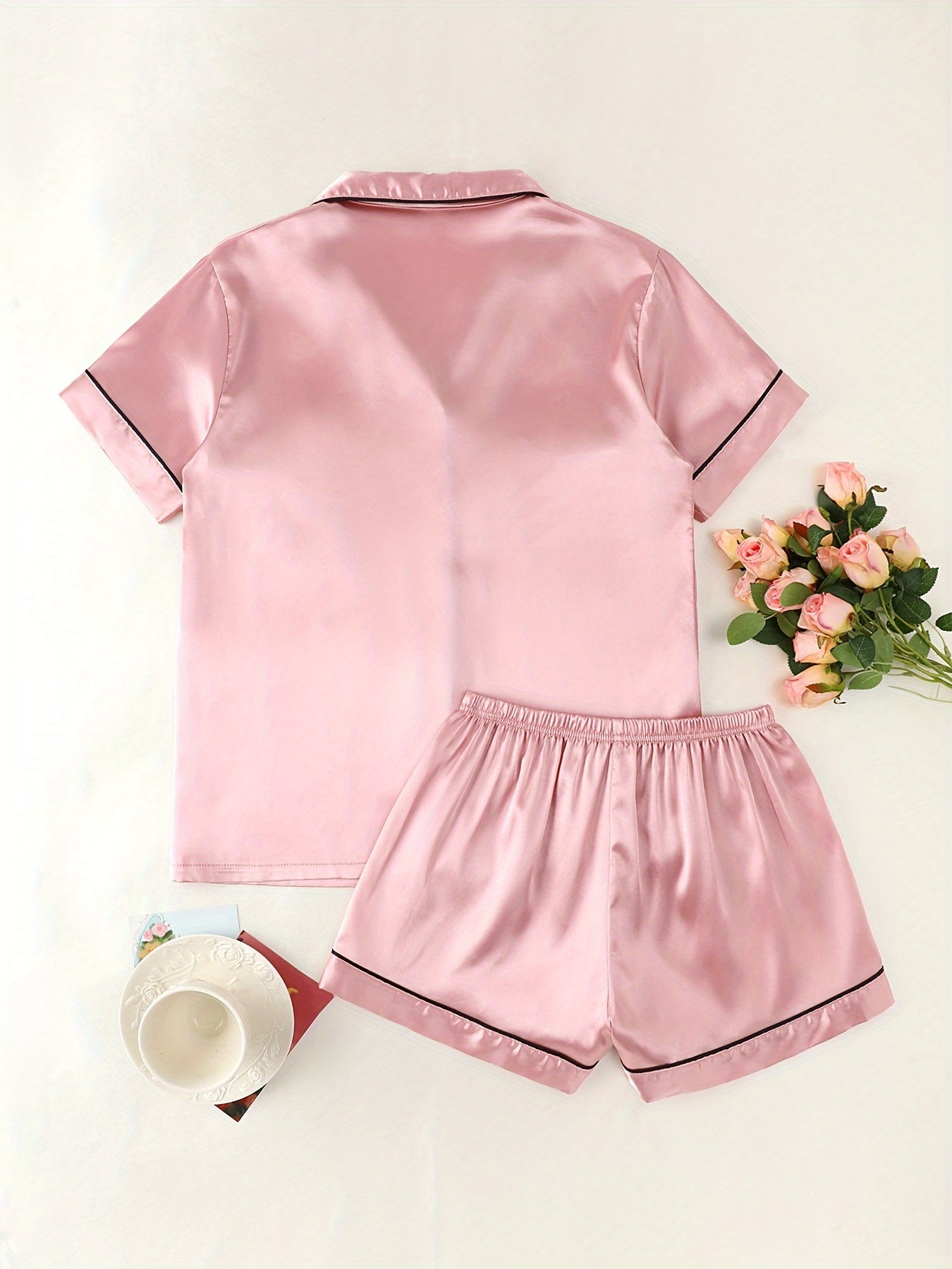 Women's satin pajama set with short-sleeve top and button-up shorts.