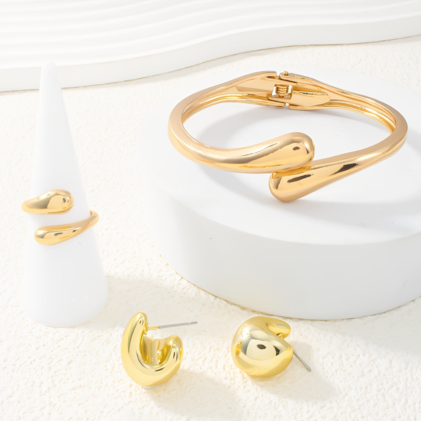 A set of women's jewelry, including earrings, a ring, and a bracelet with a spring design, ideal for everyday elegance.