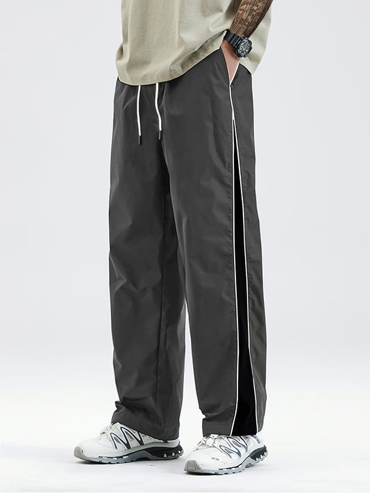 Men's black lightweight joggers with drawstring waist, perfect for spring and fall. Made of polyester fabric with a loose fit and glossy finish.