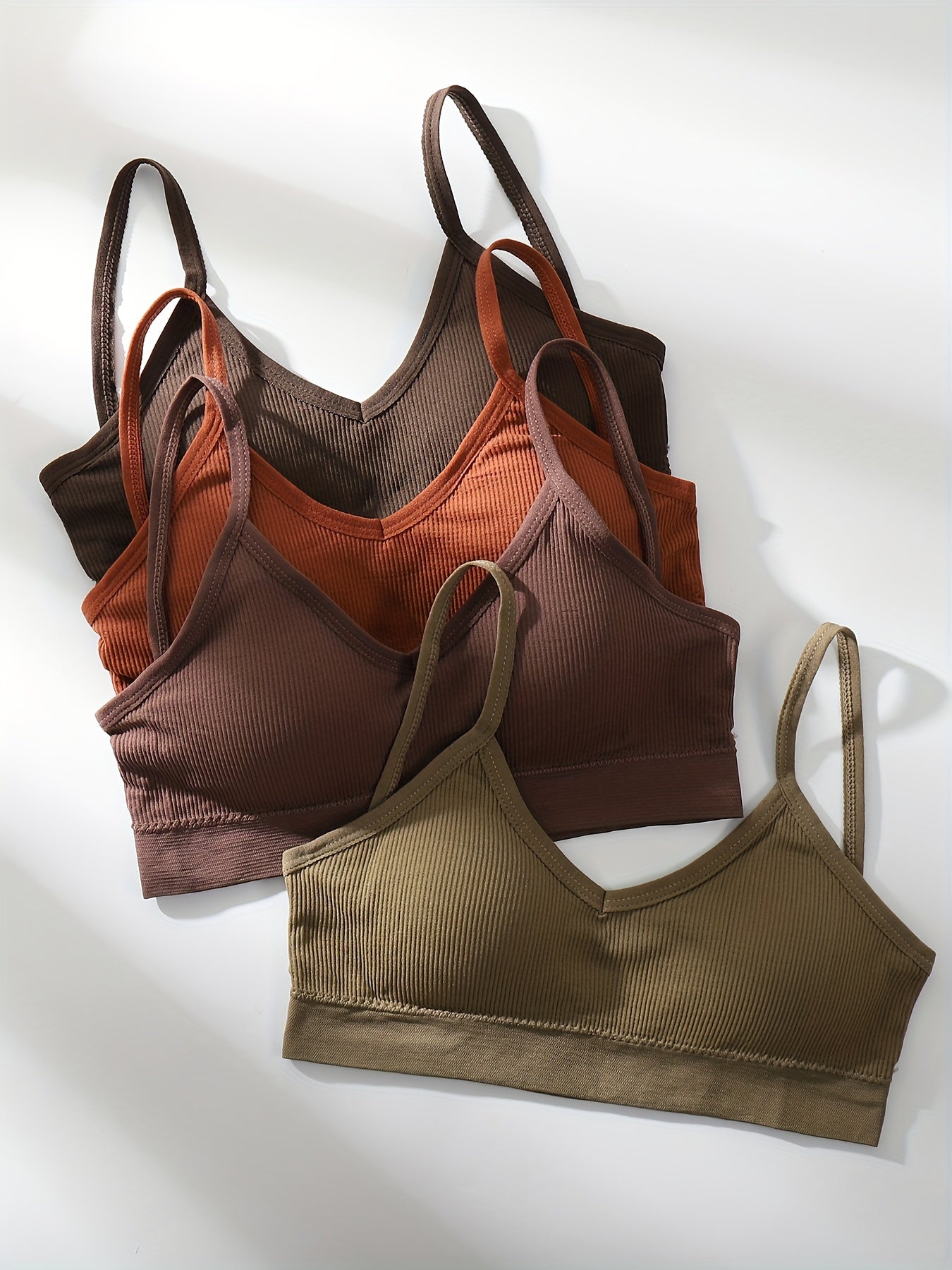 Four wireless bras made of solid ribbed material that are comfortable, breathable, and stretchy. Ideal for women looking for lingerie and underwear.