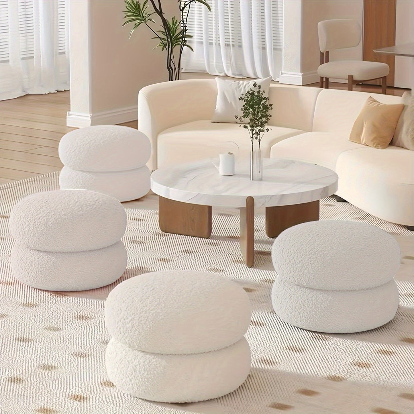 White polyester sofa stool that is versatile and compact. This round ottoman is ideal for the living room, great for changing shoes and enhancing home decor. Features a contemporary style.