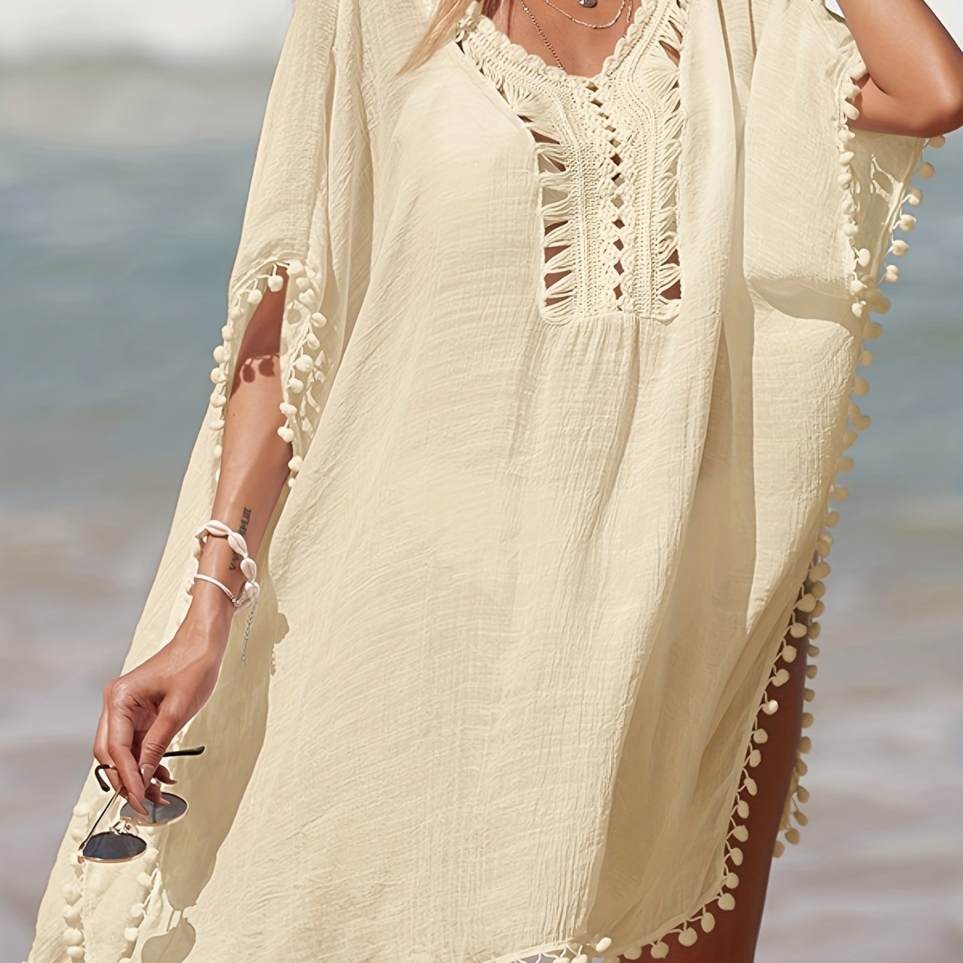 Bohemian style crochet cover up with batwing sleeves, side split, and sheer fabric for beach sun protection.