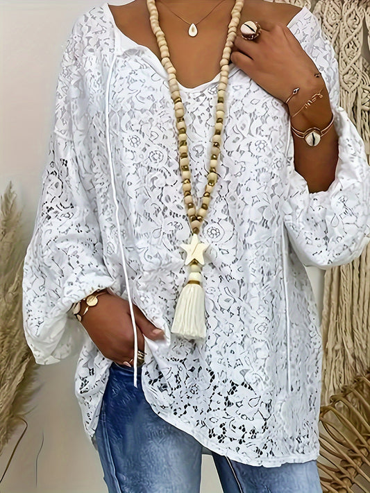 Plus size white V-neck long sleeve knit top with floral cut-out design, loose fit and lightweight polyester blend for summer wear. Features tassel necklace and lightweight knit fabric.