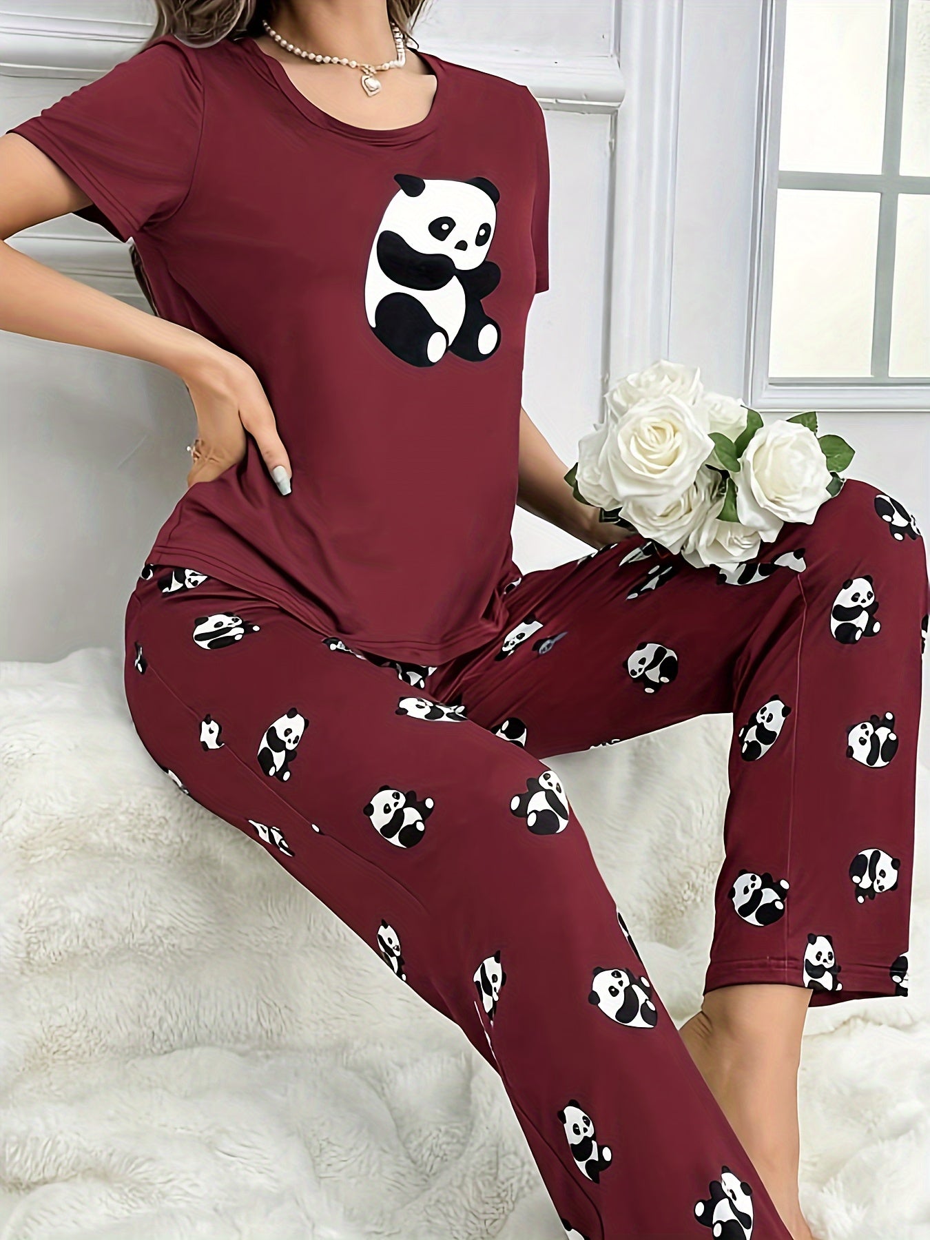 Women's sleepwear set with cute panda print, short sleeve top, and elastic pants.