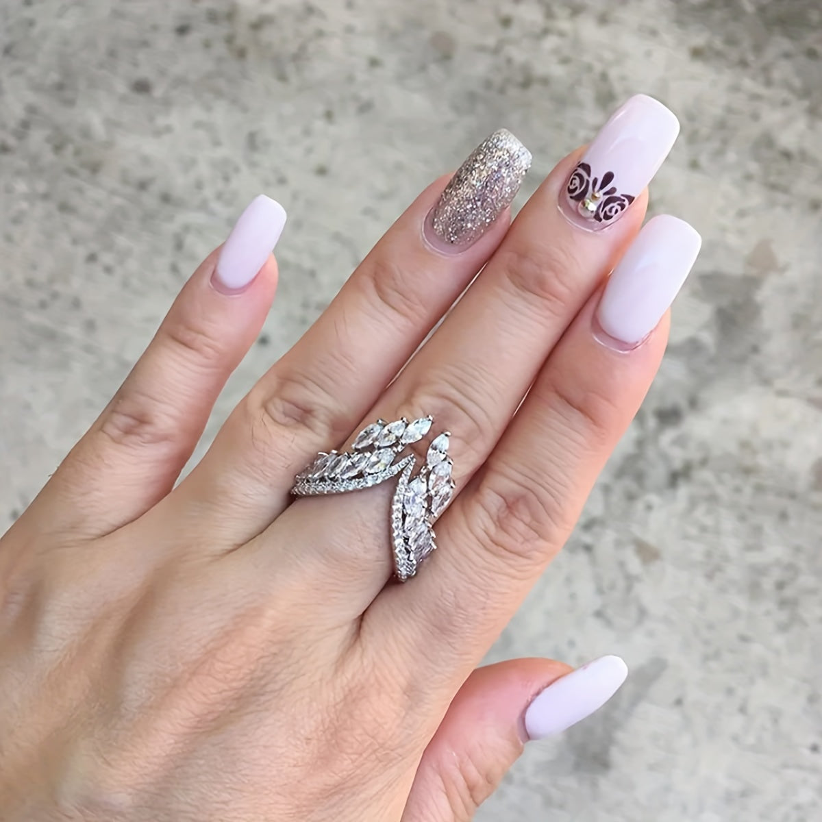 A pair of engagement and wedding rings and bracelets adorned with the wings of a female angel.