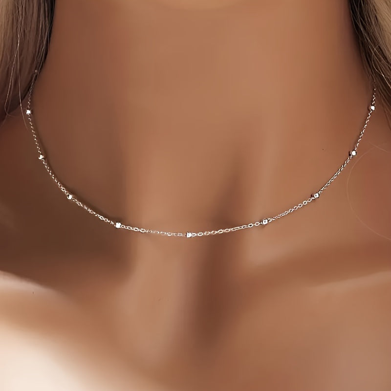 An elegant 925 silver necklace featuring 2 grams of shimmering beads, a delicate collarbone chain, and a stylish piece of jewelry designed for women.