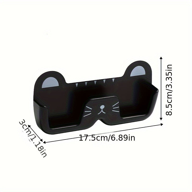 Wall-mounted whimsical cat eyeglass holder made of punch-free plastic, designed to store and display glasses in a space-saving and fashionable manner.