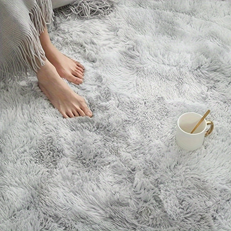 A stylish light grey tie-dye gradient plush carpet perfect for your living room, coffee table, or bedside. This long-haired washable mat is ideal for adding a touch of Nordic style to your bedroom.