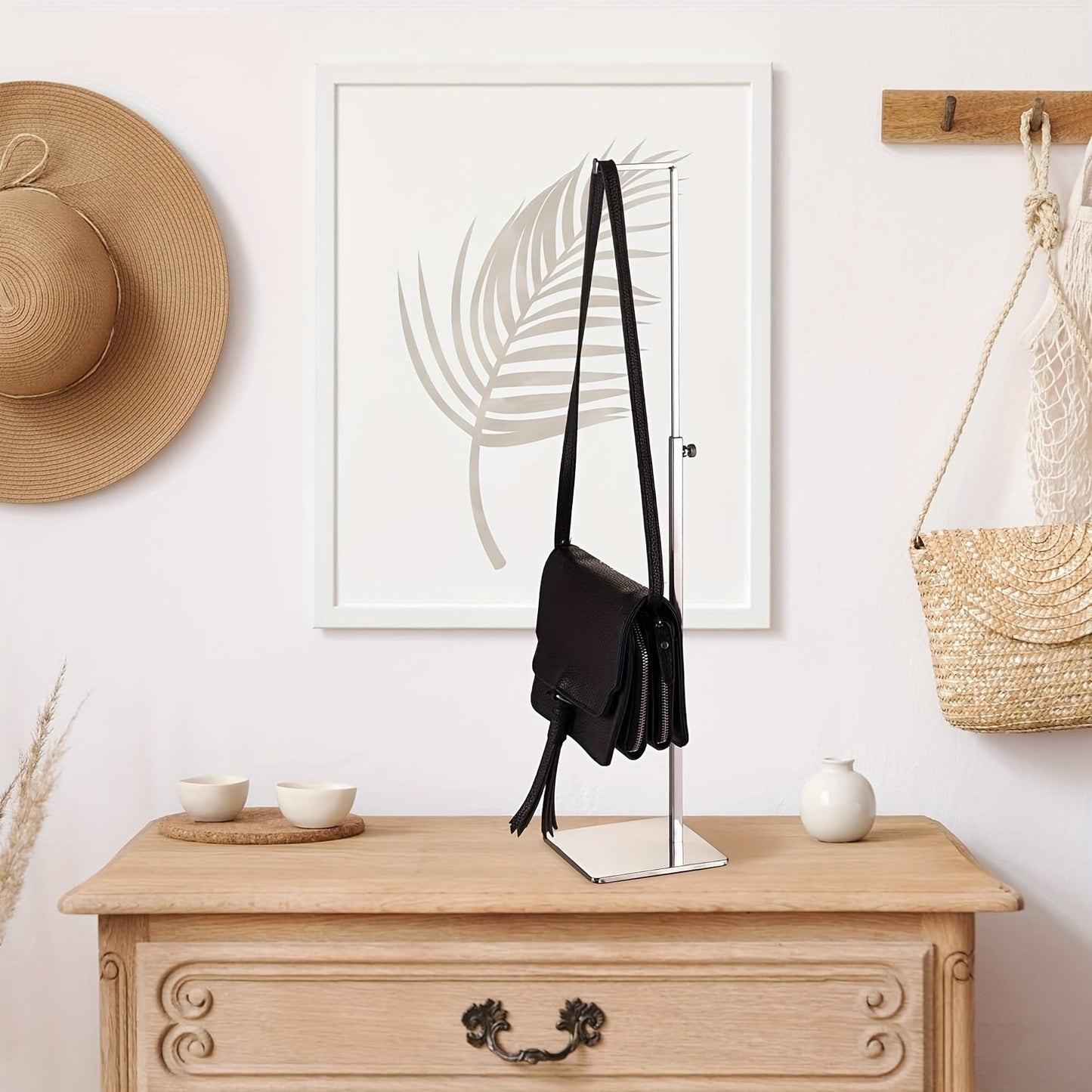 This elegant purse display stand features a single adjustable hook, perfect for showcasing handbags in both retail and home settings. Made from sturdy, silvery metal with a weighted base for added stability.