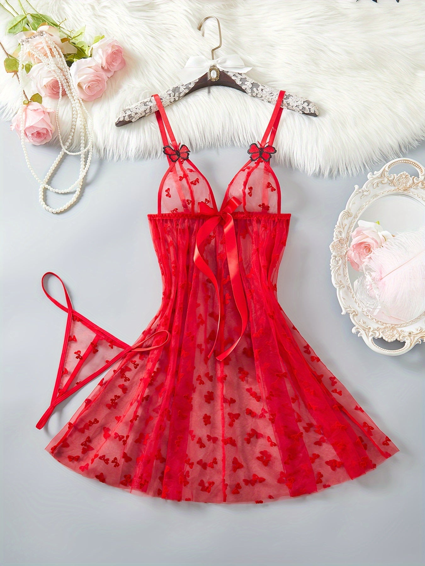 Elegant red mesh lingerie set for women with butterfly pattern babydoll and large bow detail. A sensual adult costume.