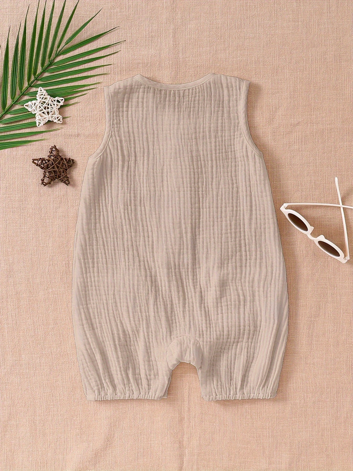 A white sleeveless vest paired with a one-piece jumpsuit.