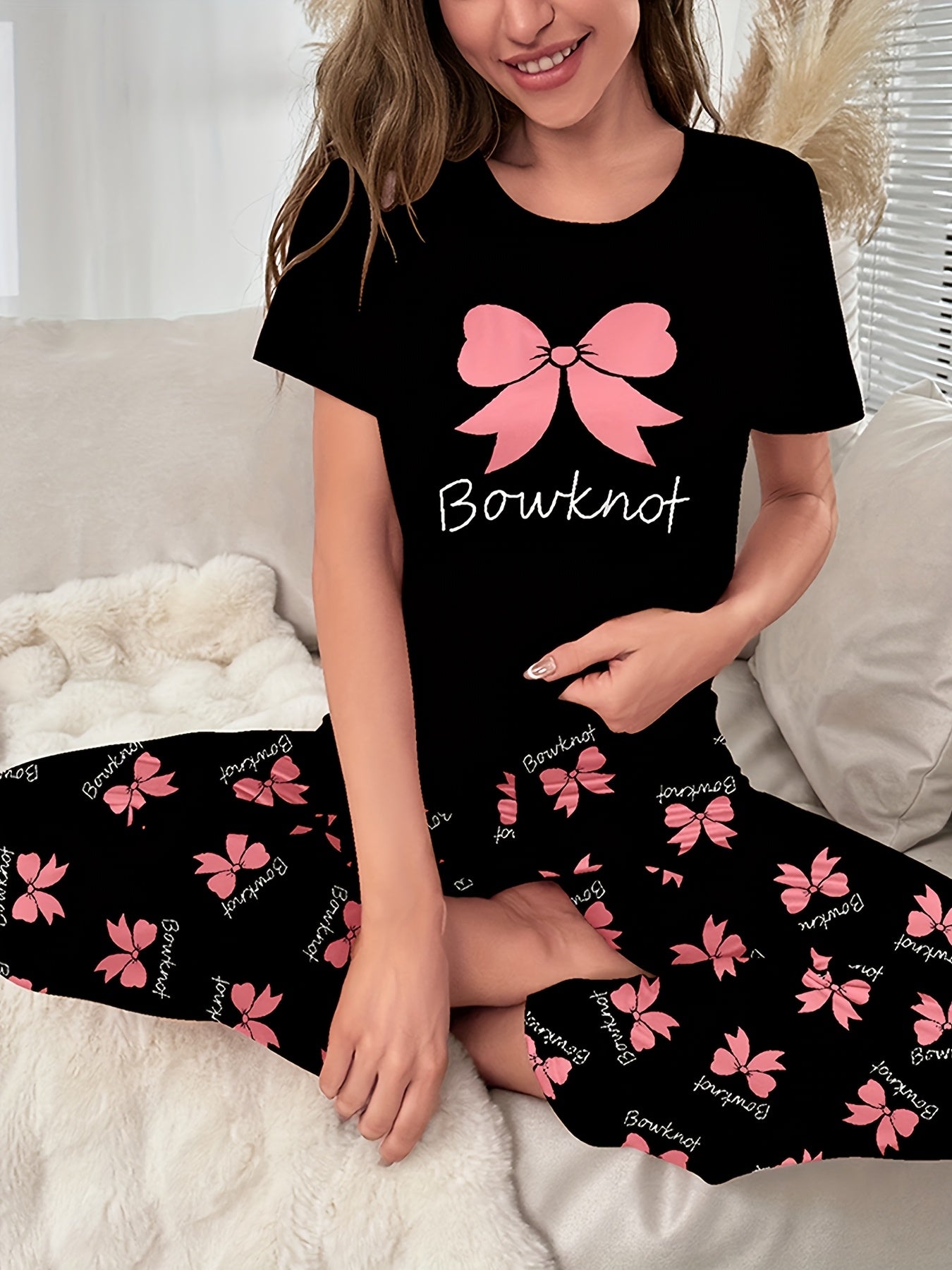 Women's sleepwear set with bow & slogan print, short sleeve top, and elastic pants.