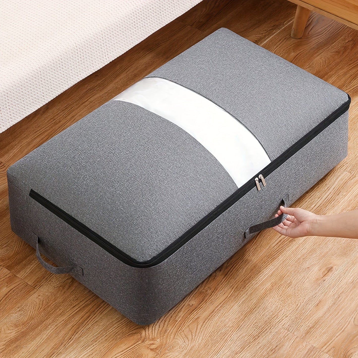 Under-bed storage bag with transparent window, handle, and generous capacity for storing clothes, quilts, and blankets.