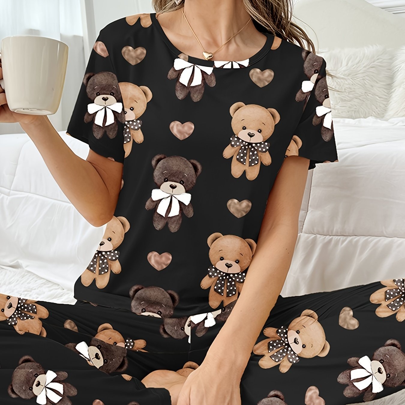 Women's sleepwear set with cartoon bear and heart print, featuring a cozy short sleeve top and elastic pants.