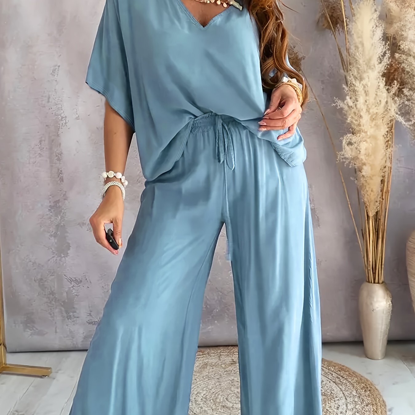 Women's clothing set with solid color pants, half sleeve V neck top, and wide leg pants.