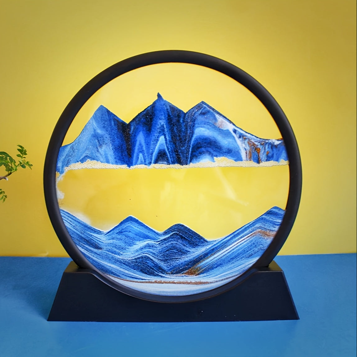 Large round glass frame with flowing sand creates a 3D deep sea scene as a relaxing home and office decoration.