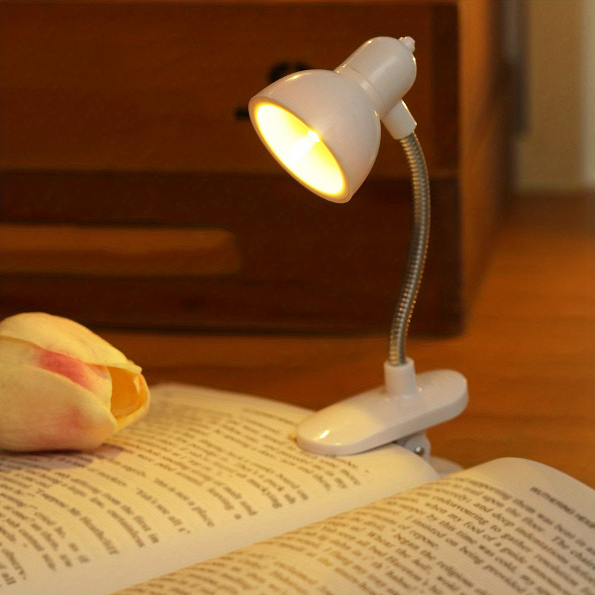 Mini clip-on reading lamp with push button control, adjustable arm, and fantasy-themed brushed finish made of plastic material. Battery operated for bedroom tabletop use as a night light.