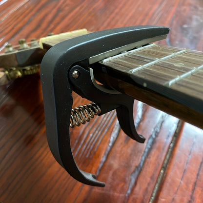 Quick change guitar capo clip for acoustic, classic, electric guitars, and ukulele. Universal adjustable clip.