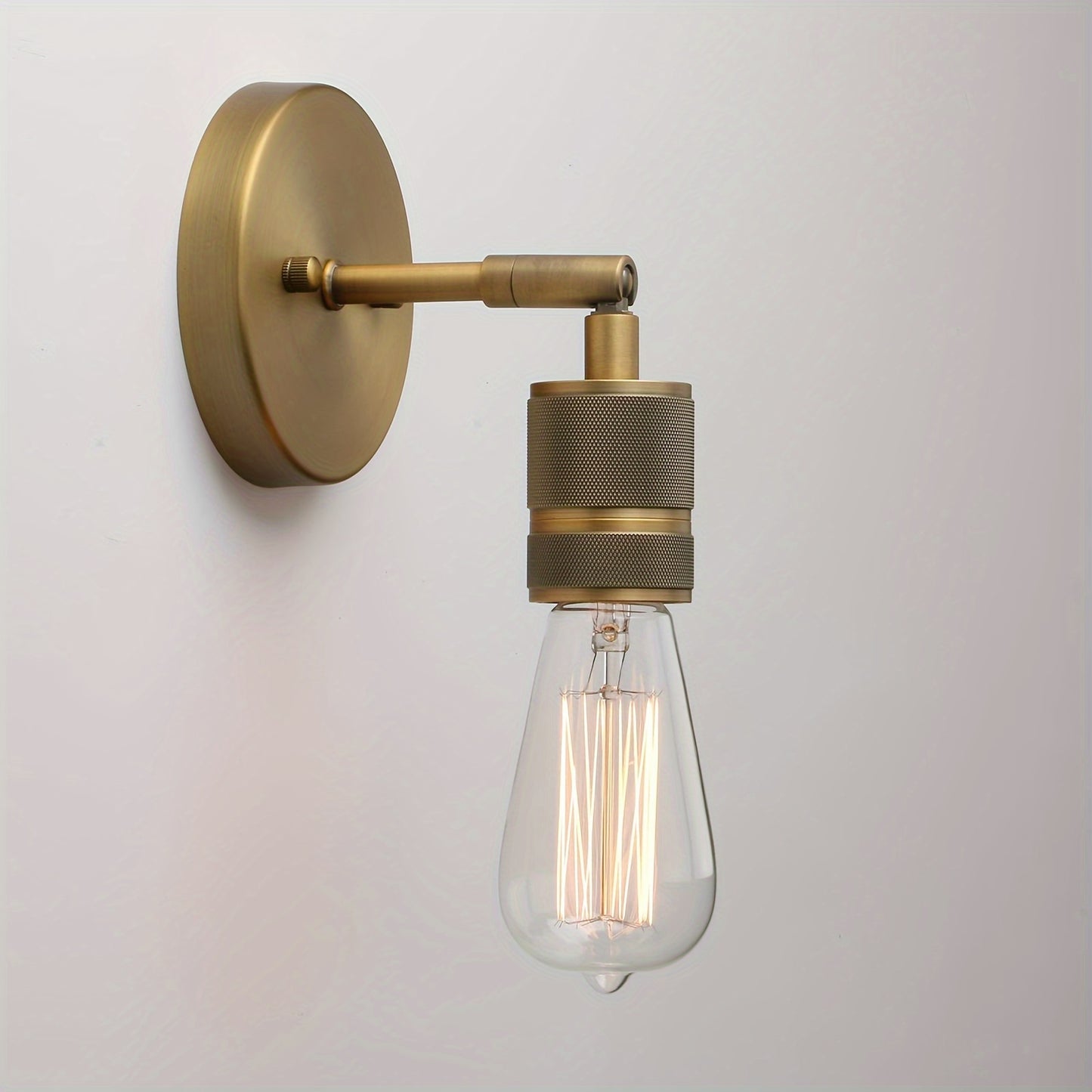 Vintage industrial wall sconce in antique bronze metal finish, suitable for various rooms.