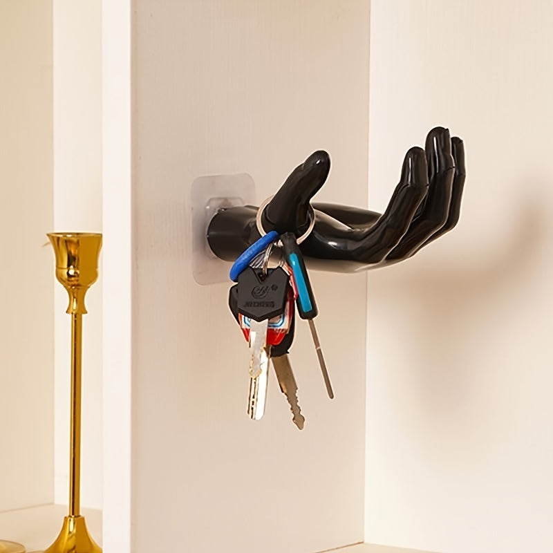 Palm-shaped adhesive wall hook for strong, no-drill, traceless storage of keys and headphones at home.