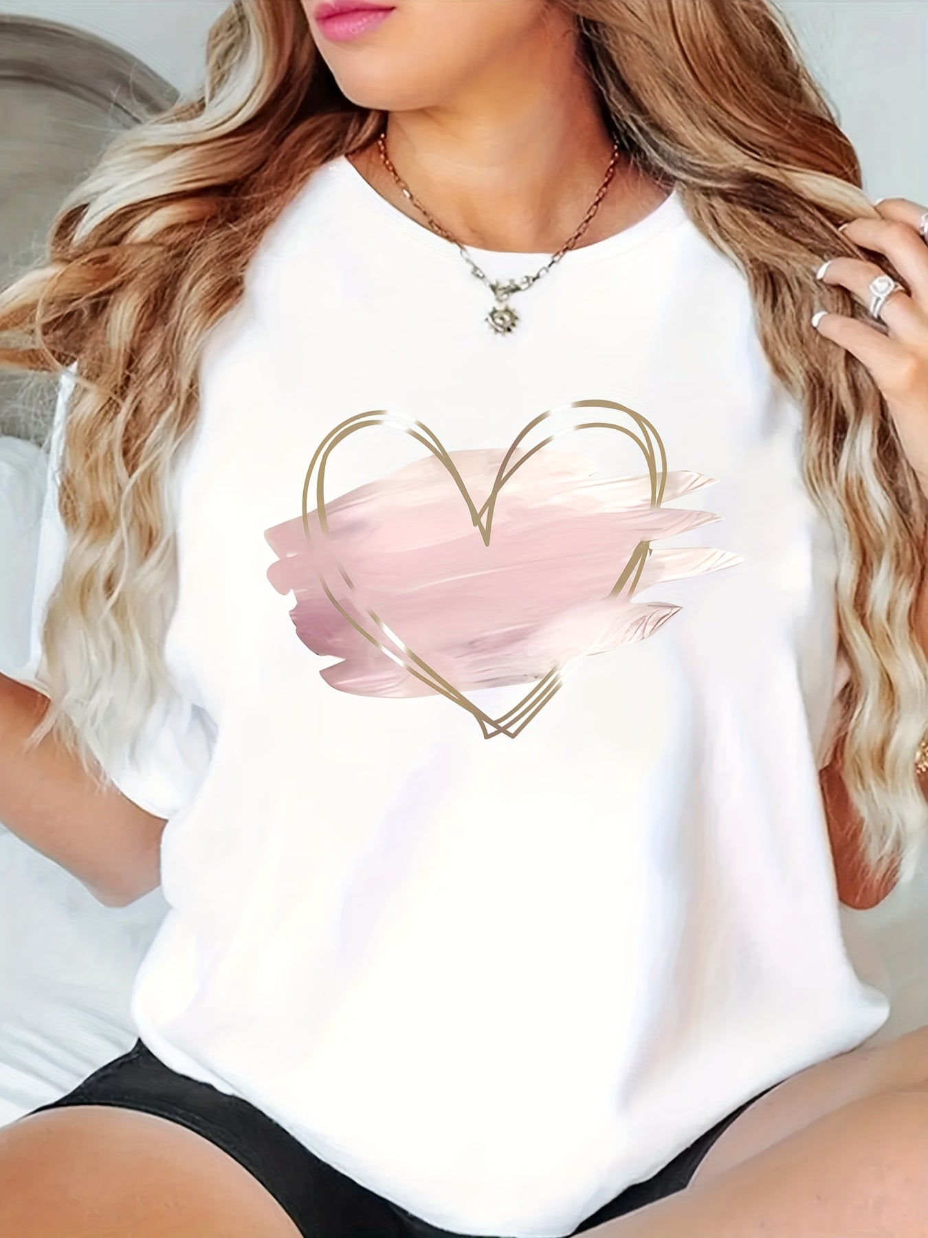 Stylish plus size T-shirt with pink heart print, crew neck, short sleeves, and medium stretch polyester knit fabric. Features applique detail, perfect for spring, summer, and fall.