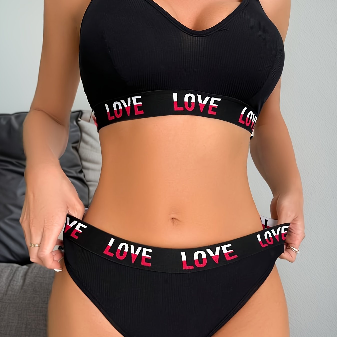 Stylish 'LOVE' printed bra and panties set for women. Includes wireless, comfortable lingerie with high-waisted elastic thong. Made from polyester and elastane blend, non-see-through