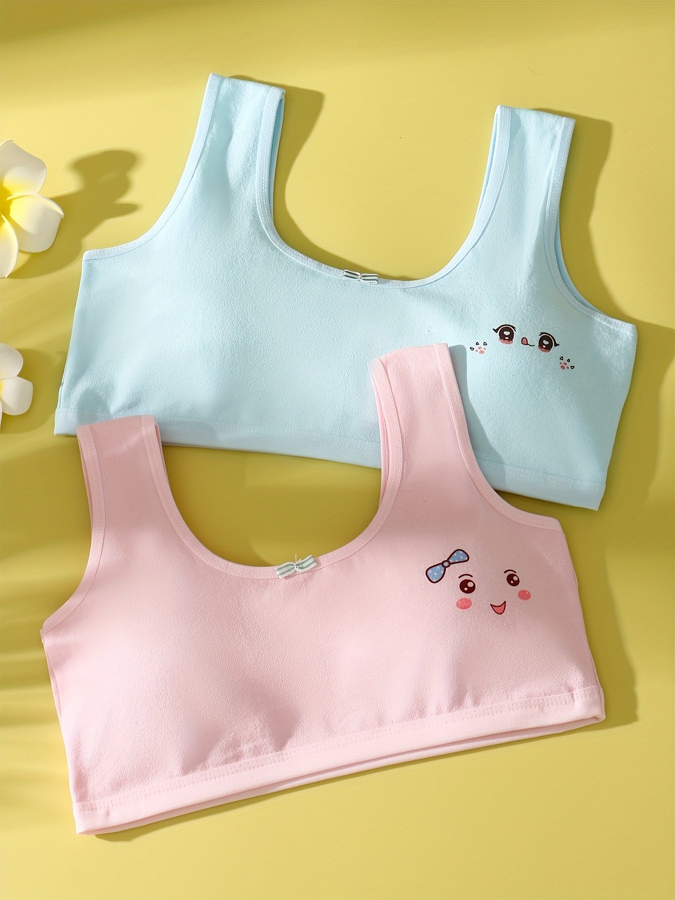 4 comfy cotton bras for girls aged 7-13 with cute animal illustrations in solid colors. Stretchy and machine washable. Includes white, yellow, blue, pink. Ideal for elementary to high