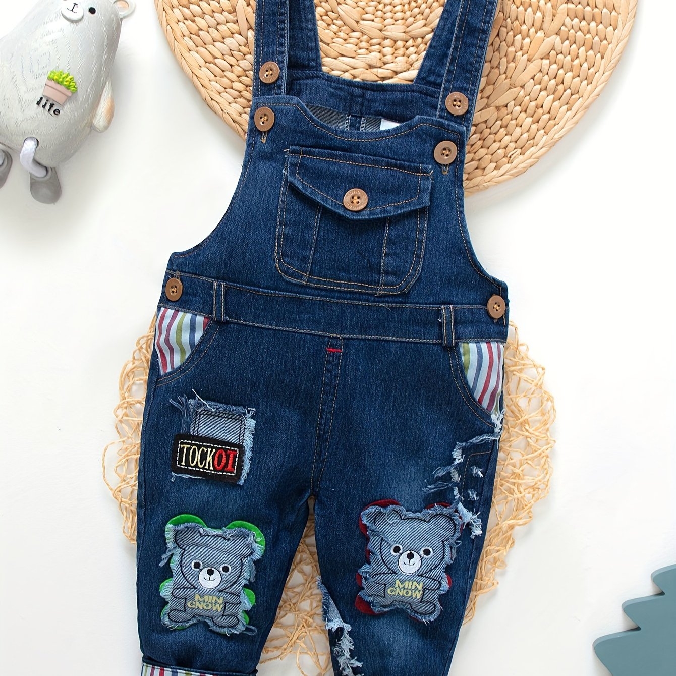 Children's denim overalls with embroidered animal designs, made of a cotton blend with slight stretch, suitable for outdoor wear in the spring and fall.